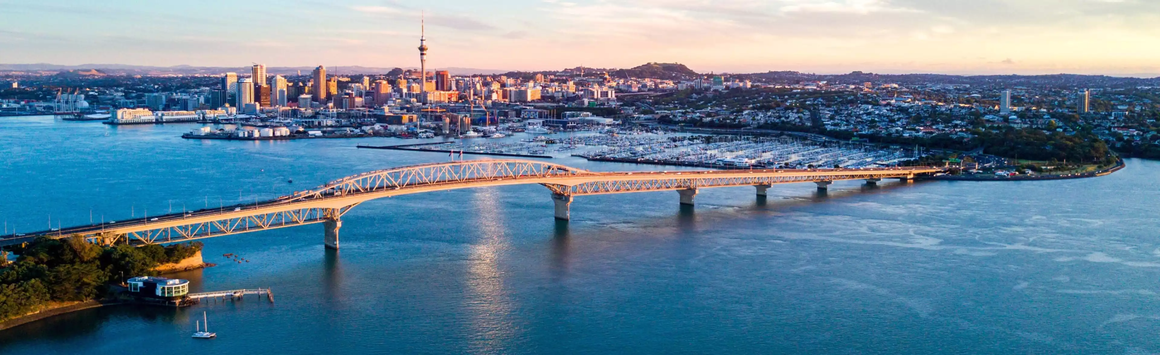 City skyline and harbor bridge at sunset